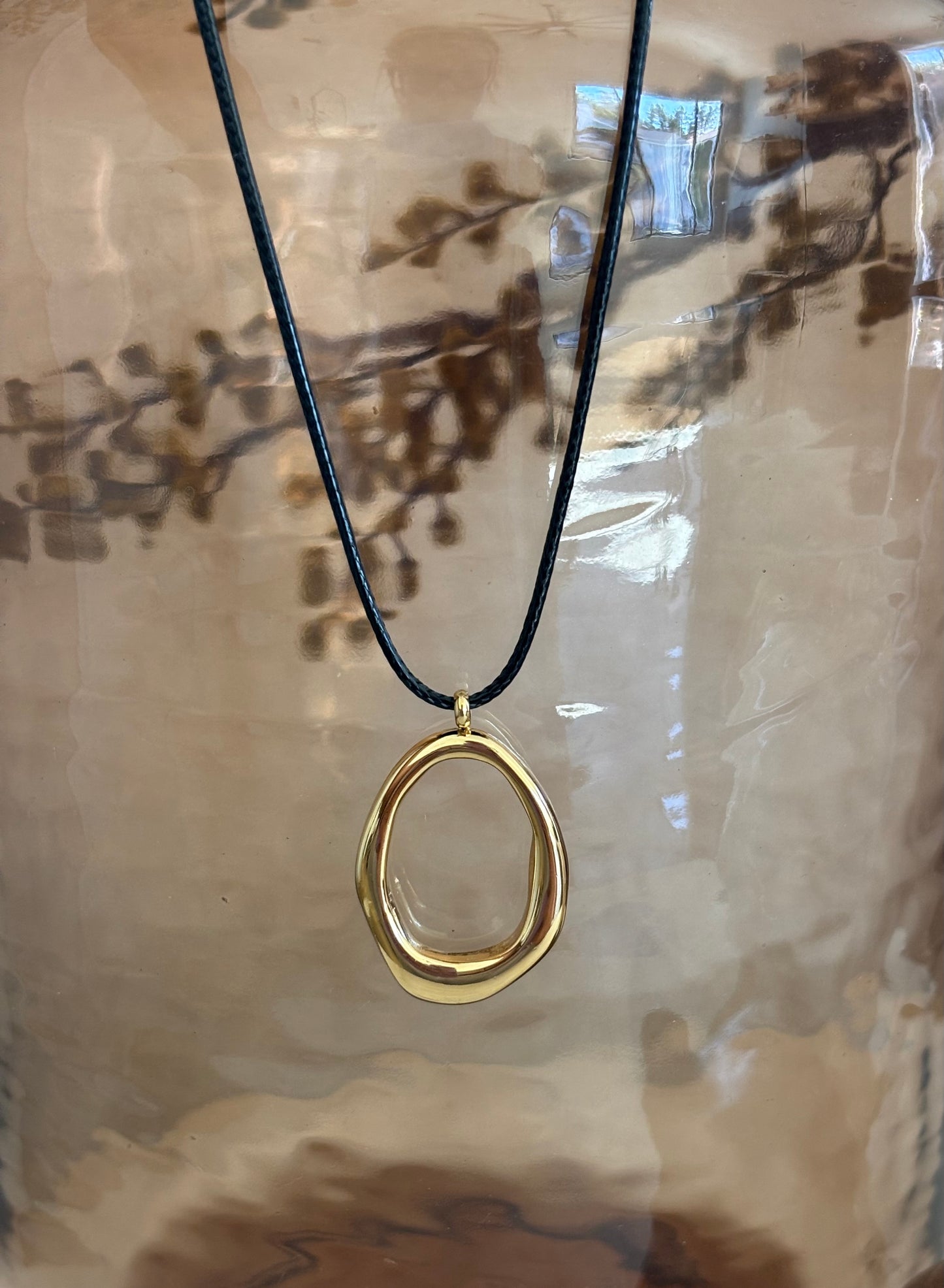 Close up of autum necklace with a brown glass background and fall foliage