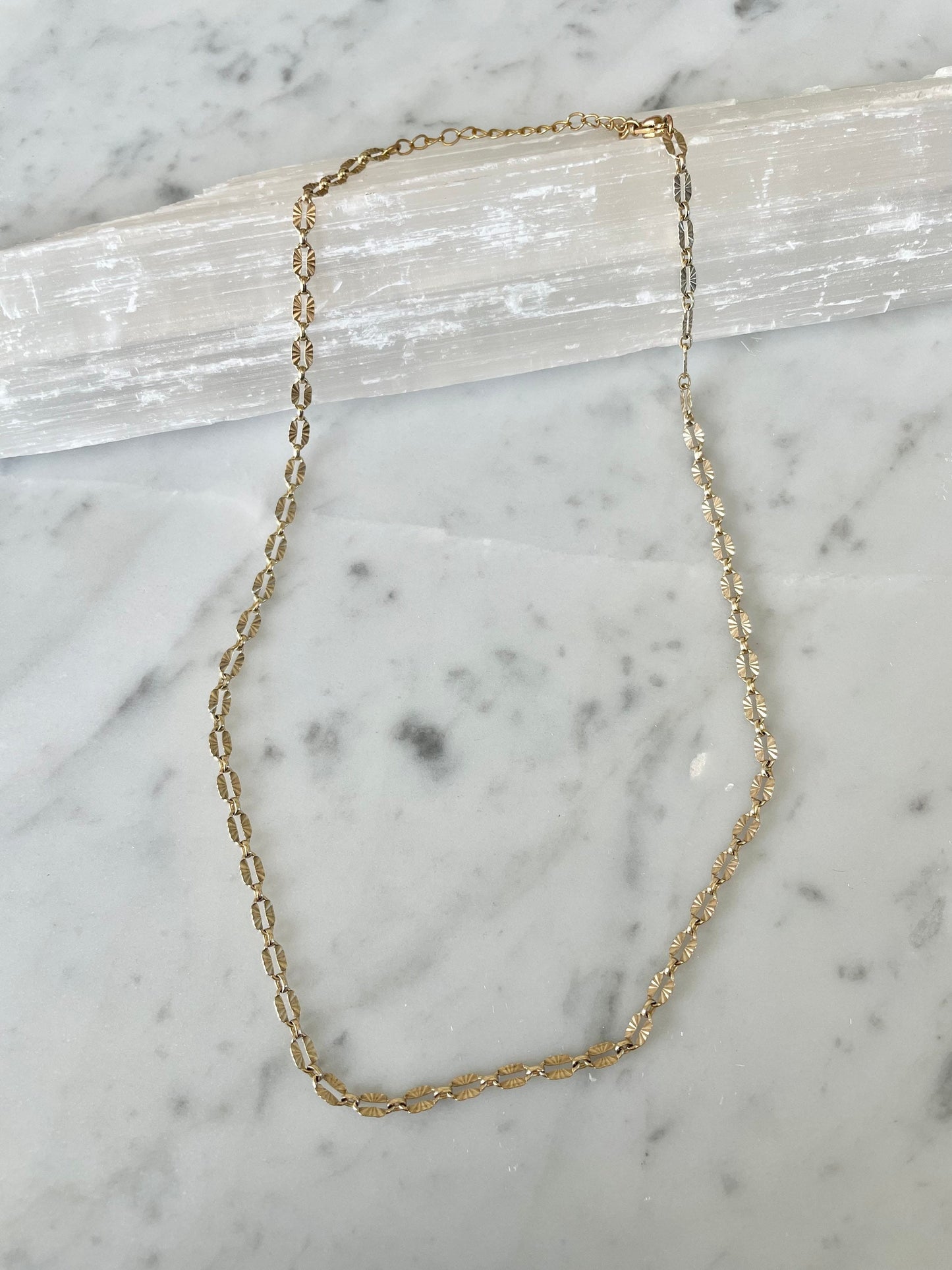 gold filled sunburst necklace on marble