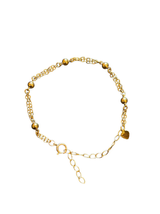 Gold bracelet with beads on a white background